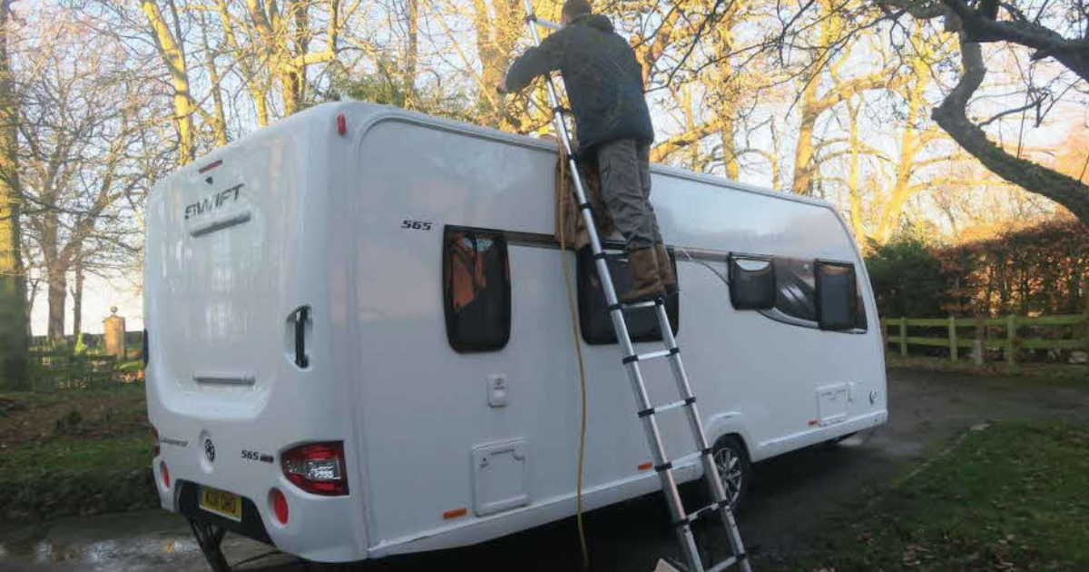 Técnico a limpar e proteger o tecto de autocaravana em ambiente exterior — manutenção completa em climas costeiros de Portugal e Espanha