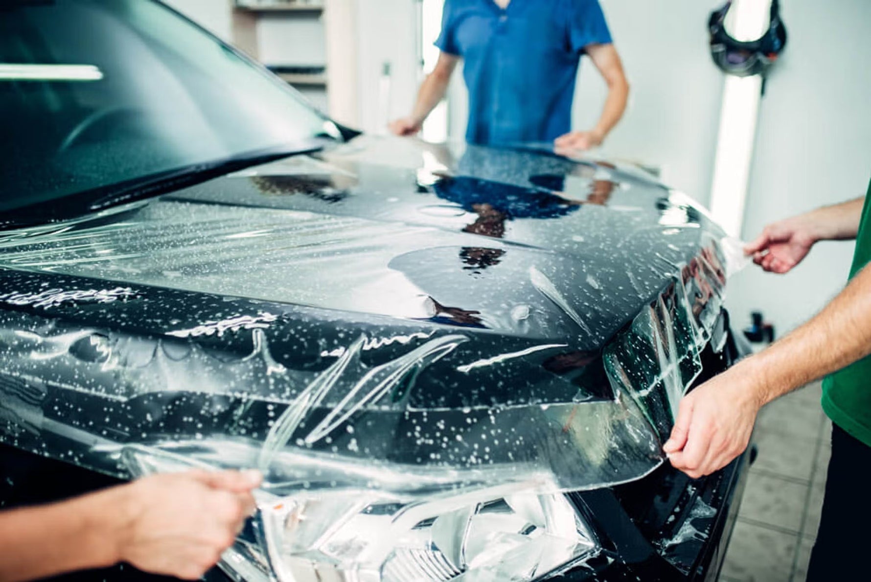 Instalação profissional de PPF película de proteção de pintura transparente no capot de automóvel negro — Detaildawg distribuidora oficial Portugal e Espanha